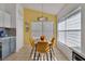 Sunny dining area with modern light fixture, large windows, and stylish yellow chairs at 577 Eagle Pointe S, Kissimmee, FL 34746