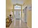 Bright entryway featuring tile flooring, transom window, and neutral yellow wall paint at 577 Eagle Pointe S, Kissimmee, FL 34746