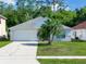Charming single-story home featuring a well-manicured lawn, a two-car garage, and lush trees at 577 Eagle Pointe S, Kissimmee, FL 34746