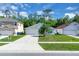 Charming single-story home with a well-maintained lawn, concrete driveway, and tropical palm tree at 577 Eagle Pointe S, Kissimmee, FL 34746