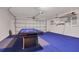 A garage featuring a pool table, closed white garage door, and blue painted floors at 577 Eagle Pointe S, Kissimmee, FL 34746