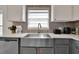 Modern stainless steel farm sink with stylish faucet, decorative backsplash, and updated countertops at 577 Eagle Pointe S, Kissimmee, FL 34746
