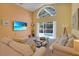 Bright living room featuring a large window overlooking the pool area, and comfortable sofas at 577 Eagle Pointe S, Kissimmee, FL 34746