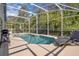 Inviting screened-in pool area with lounge chairs, a patio set, and a beautiful backyard view at 577 Eagle Pointe S, Kissimmee, FL 34746
