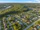 Wide angle aerial view of large neighborhood bordering forest and a body of water at 638 Kangaroo Dr, Poinciana, FL 34759