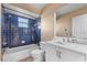 Bathroom featuring a navy blue tiled shower/tub, vanity with a mirror, and neutral color walls at 638 Kangaroo Dr, Poinciana, FL 34759