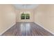 Bedroom features wood-look floors, neutral paint, and a window overlooking the lush landscaping at 638 Kangaroo Dr, Poinciana, FL 34759