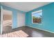 Bright turquoise bedroom with a closet and a view to the outside featuring tropical plants at 638 Kangaroo Dr, Poinciana, FL 34759