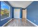 Blue bedroom with a closet and a window showcasing a lush green view at 638 Kangaroo Dr, Poinciana, FL 34759