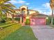 Charming home boasts a well-maintained lawn, arched entry, and a pink two-car garage at 638 Kangaroo Dr, Poinciana, FL 34759
