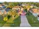 Aerial view of two-story home with brick driveway, a pink garage door, and mature landscaping at 638 Kangaroo Dr, Poinciana, FL 34759