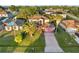 Aerial view of two-story home with brick driveway, a pink garage door, and mature landscaping at 638 Kangaroo Dr, Poinciana, FL 34759