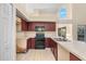 Kitchen features wood cabinets, black appliances, and tile flooring with a double sink at 638 Kangaroo Dr, Poinciana, FL 34759