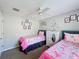 Bedroom featuring twin beds, cartoon wall art, carpeted floor, and a ceiling fan at 661 Sandy Ridge Dr, Davenport, FL 33896