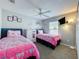 Bedroom featuring twin beds, cartoon wall art, carpeted floor, and a ceiling fan at 661 Sandy Ridge Dr, Davenport, FL 33896