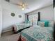 Bedroom with carpeted floors, ceiling fan, and 2 twin beds with decorative pillows at 661 Sandy Ridge Dr, Davenport, FL 33896