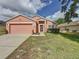 Charming single-story home features a two-car garage and well-manicured lawn at 661 Sandy Ridge Dr, Davenport, FL 33896