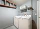 Functional laundry room features a washer, dryer, shelving and a convenient closet for storage at 661 Sandy Ridge Dr, Davenport, FL 33896