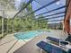 Beautiful screened pool with spa and chairs for soaking up the sun at 661 Sandy Ridge Dr, Davenport, FL 33896
