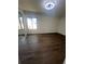 Bright bedroom featuring dark hardwood floors, a large window and sliding mirrored closet doors at 664 Lake Villas Dr, Altamonte Springs, FL 32701