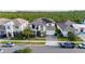 An aerial view shows a pristine white home, fitted with solar panels, nestled in a beautifully maintained community at 6953 Broglie St, Orlando, FL 32827