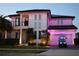 Elegant two-story home featuring a balcony, manicured lawn, and a golf cart parked in front of a two car garage at 6953 Broglie St, Orlando, FL 32827