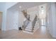 Bright foyer with a modern staircase featuring wood steps and metal railings at 6953 Broglie St, Orlando, FL 32827