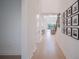 Bright hallway with hardwood floors and decorative wall art leading to an open concept living area at 6953 Broglie St, Orlando, FL 32827