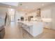 Open-concept kitchen with white cabinetry, large island with seating, and stainless steel appliances at 6953 Broglie St, Orlando, FL 32827