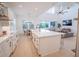 Bright kitchen with white cabinets, island with seating, and an open view to the living room and backyard at 6953 Broglie St, Orlando, FL 32827