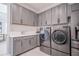 A spacious laundry room equipped with modern washer and dryer, sleek cabinetry, and ample counter space at 6953 Broglie St, Orlando, FL 32827