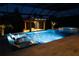 Sparkling swimming pool at night featuring a waterfall feature, illuminated water, and multiple lounge chairs at 6953 Broglie St, Orlando, FL 32827