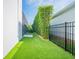 Side yard showcases a well-maintained artificial lawn and privacy landscaping at 6953 Broglie St, Orlando, FL 32827