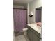 Bathroom featuring single sink vanity, and a tub-shower combo with gray tiling and butterfly-themed shower curtain at 804 Timberland Dr, Eagle Lake, FL 33839