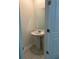 Clean half bath featuring a pedestal sink, mirror, and white door, perfect for guests at 804 Timberland Dr, Eagle Lake, FL 33839