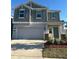 Charming two-story home with a two-car garage, green door, neutral colors and well-maintained landscaping at 804 Timberland Dr, Eagle Lake, FL 33839