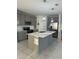 Bright kitchen features gray cabinets, stainless appliances, and a large island with a sink and counter seating at 804 Timberland Dr, Eagle Lake, FL 33839