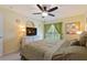 Comfortable bedroom with a large window, curtains, ceiling fan, and a flat screen television at 8374 Quimby Cir # 8374, Davenport, FL 33896