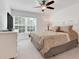 Bright primary bedroom with a ceiling fan and large window at 8374 Quimby Cir # 8374, Davenport, FL 33896