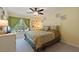 Cozy bedroom with a large window, curtains, ceiling fan, and a comfortable bed at 8374 Quimby Cir # 8374, Davenport, FL 33896