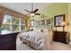 Tranquil bedroom features a decorative iron bed frame and a large window with views at 8374 Quimby Cir # 8374, Davenport, FL 33896