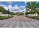 Elegant clubhouse entrance with manicured landscaping and inviting brick-paved drive at 8374 Quimby Cir # 8374, Davenport, FL 33896