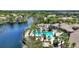 Aerial view of community pool with resort style amenities, lake view and lush tropical landscape at 8374 Quimby Cir # 8374, Davenport, FL 33896