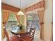 Bright dining area has a glass top table, floral window coverings, and natural light at 8374 Quimby Cir # 8374, Davenport, FL 33896