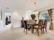 Bright dining room with a glass-topped table, seating for six, and a large window with floral curtains at 8374 Quimby Cir # 8374, Davenport, FL 33896