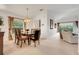 Open-concept dining area with seating for six, leading to a living room with a view of the screened lanai at 8374 Quimby Cir # 8374, Davenport, FL 33896