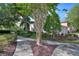 Exterior view of townhomes featuring lush trees, manicured landscaping and sidewalks at 8374 Quimby Cir # 8374, Davenport, FL 33896