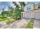 Charming townhome featuring a paved driveway, attached garage, manicured landscaping, and inviting curb appeal at 8374 Quimby Cir # 8374, Davenport, FL 33896