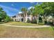 Exterior side view of home featuring screened in lanais, palm trees, and manicured landscaping at 8374 Quimby Cir # 8374, Davenport, FL 33896