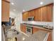 Well-equipped kitchen with stainless steel appliances, granite countertops, and cherry wood cabinets at 8374 Quimby Cir # 8374, Davenport, FL 33896